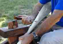 An image of a crooked knife being used to carve a paddle.