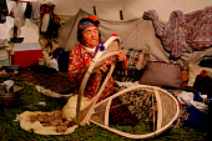 Photo of a mand making bearpaw snowshoes.