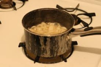 A pot of rawhide and water being heated on top of the kitchen stove.